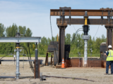 Editorial concept showing a compact verification station and a separate, larger investigation station for helical screw piles.