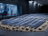 Editorial concept showing a generic ground-mount PV array model inside an atmospheric boundary-layer wind tunnel.