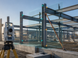 Conceptual total-station survey of a partially erected steel frame before geometry-state release.